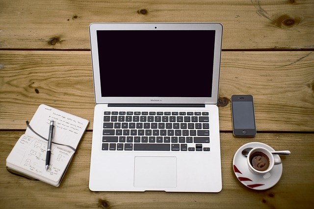 copy writers blogs laptop sitting on a wooden desk